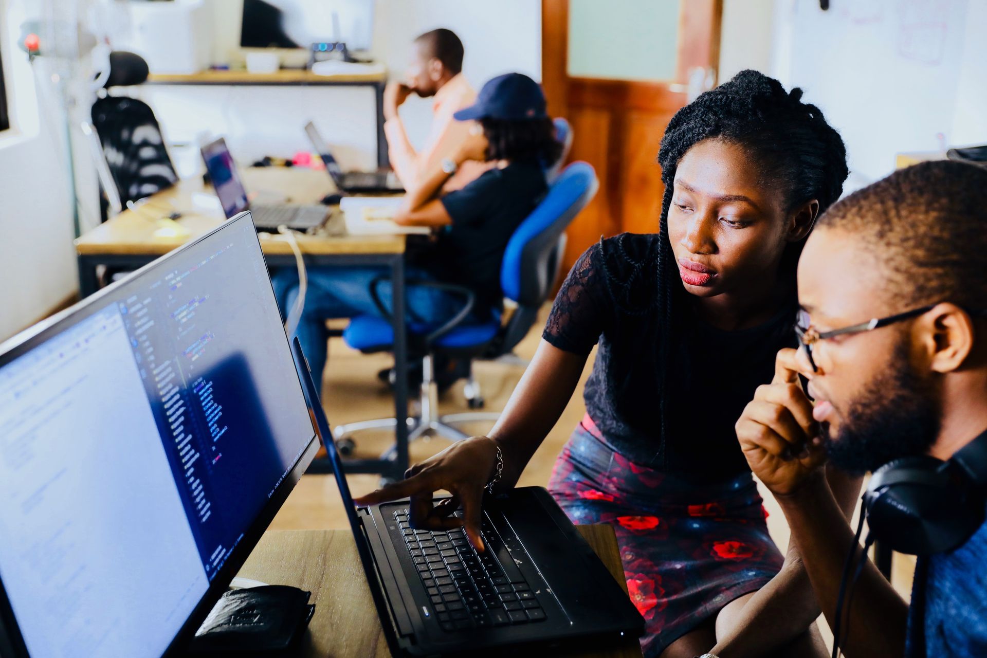 Digital professionals collaborating around a laptop